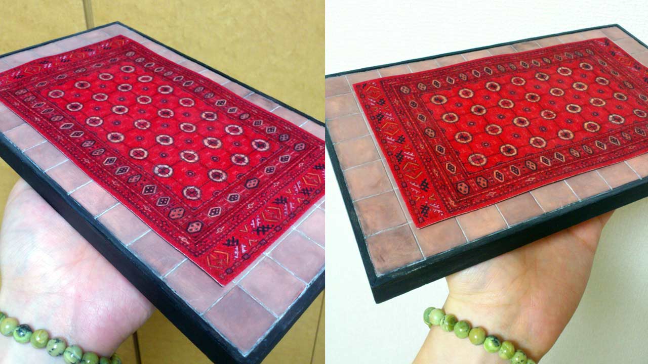 Two images side by side in a close up showing Marten Go's hand holding the finished base with the detailings of the base and miniature Afghani rug