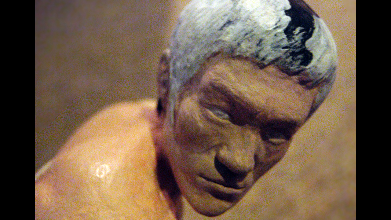 One close up image of the miniature sculpted head and face of Tang Lung